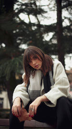 Young woman sitting on tree