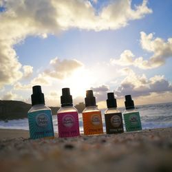 Multi colored bottles on beach against sky