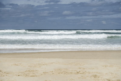 Scenic view of beach and sea against cloudy sky