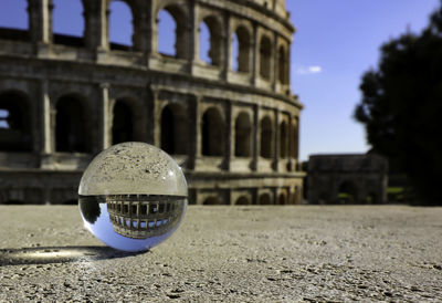 Close-up of crystal ball against colosseum