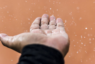 Close-up of water splashing on human palm