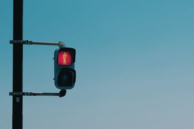 Low angle view of road signal against clear blue sky