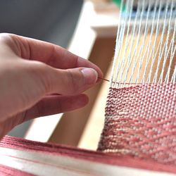 Cropped image of woman hand weaving thread