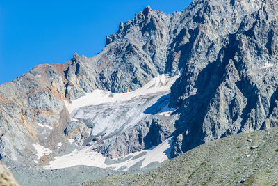 Snowcapped mountains against clear blue sky