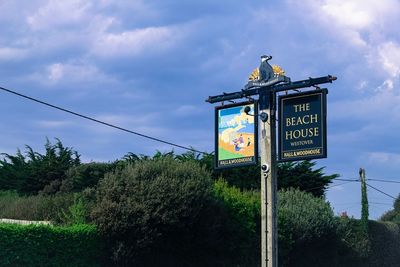 Low angle view of information sign against sky