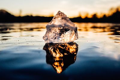 Close-up of ice floating on lake sky during sunset