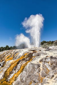 Panoramic view of geyser against sky