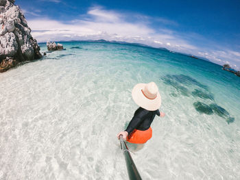 Woman on beach against sky