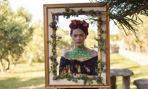 Portrait of young woman against plants