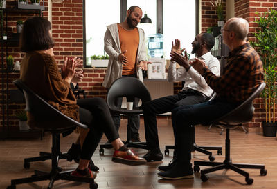 Side view of friends using laptop at gym