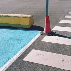 Traffic cone on road by zebra crossing