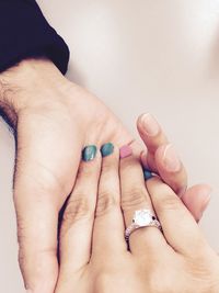 Cropped image of couple holding hands over white background