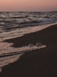 High angle view of shoes on sand at beach against sky