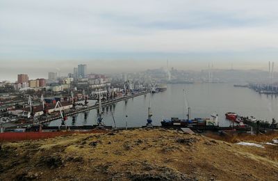 Scenic view of river by buildings against sky