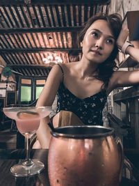 Portrait of young woman with drink in restaurant