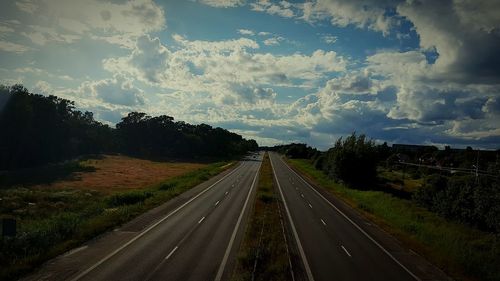 Road amidst trees against sky