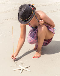 Woman writing on sand