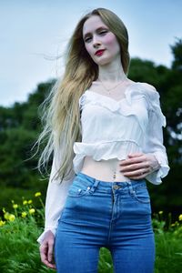 Beautiful young woman standing on field