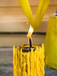 Close-up of yellow candle on table