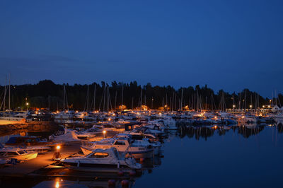 Boats moored in harbor at night