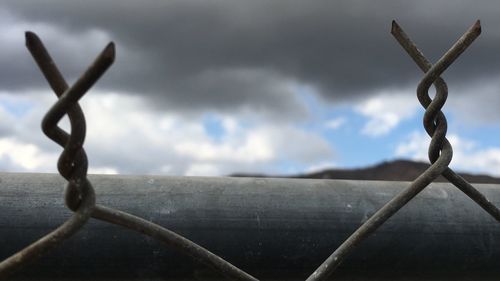 Close-up of barbed wire against sky