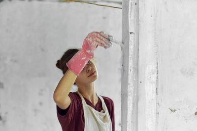 Young woman painting wall