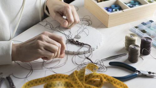 High angle view of woman working with thread on table