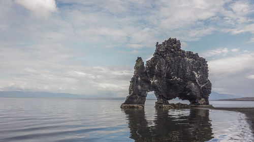 View of rock formation in sea against sky