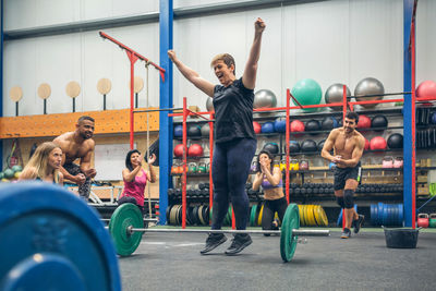 Full length of woman celebrating at gym