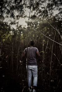 Rear view of a man standing in forest