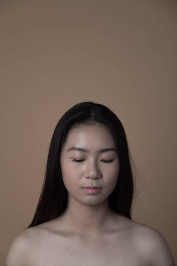 CLOSE-UP OF BEAUTIFUL YOUNG WOMAN OVER WHITE BACKGROUND