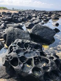 Close-up of rocks on shore against sky