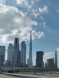 View of city buildings against cloudy sky