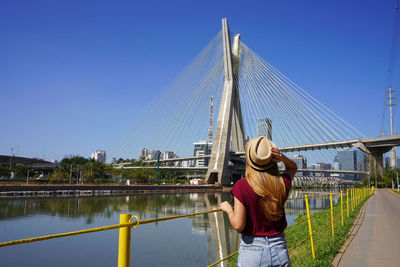 Rear view of traveler woman looking at ponte estaiada bridge in sao paulo, brazil.