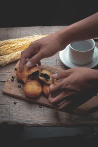 Close-up of hand holding tea cup on table