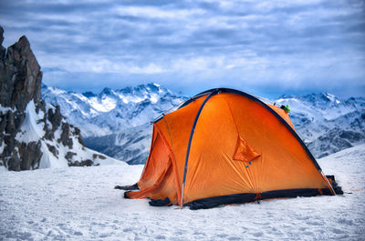 Tent on snow covered mountain against sky