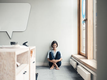 Portrait of woman sitting on wall