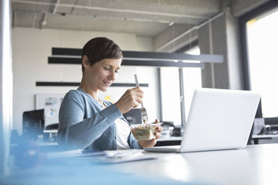 Businesswoman in office having lunch break