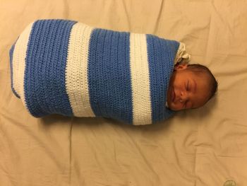 High angle view of baby sleeping on bed