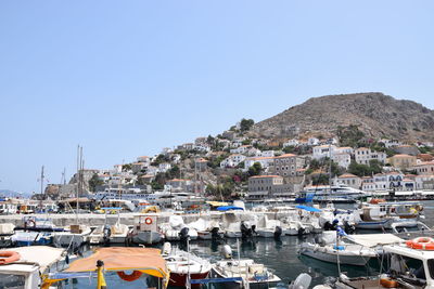 Sailboats moored at harbor against clear blue sky