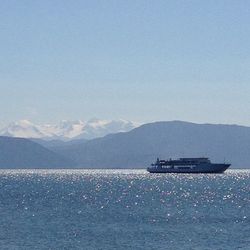 Scenic view of calm sea against mountain range