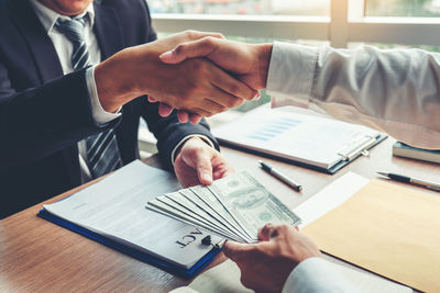 Midsection of business colleagues working at desk in office