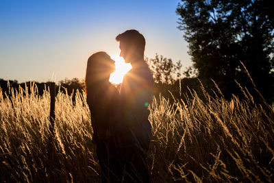 Couple standing amidst plants on field