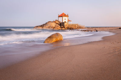 Scenic view of beach by sea against sky