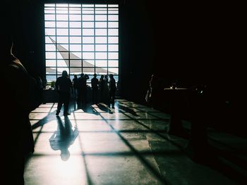 Silhouette people walking in corridor of building