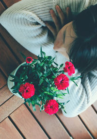 High angle view of woman leaning by vase