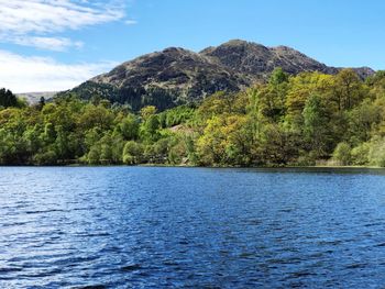 Scenic view of lake and mountains against blue sky