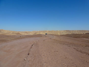 Scenic view of desert against clear blue sky