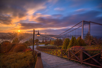 View of bridge against cloudy sky at sunset