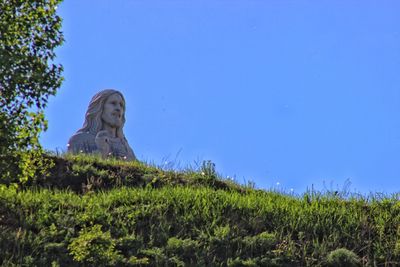 Low angle view of statue against clear blue sky